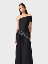 Elegant black off-shoulder gown featuring a fitted silhouette, pearl detailing, and a flowing mesh skirt for graceful movement.