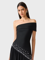 Black off-shoulder gown with a fitted bodice, intricate pearl accents, and a softly gathered mesh skirt for elegant occasions.