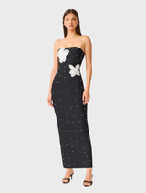 Strapless black maxi dress adorned with 3D white florals and pearl details, offering a sophisticated and modern silhouette.