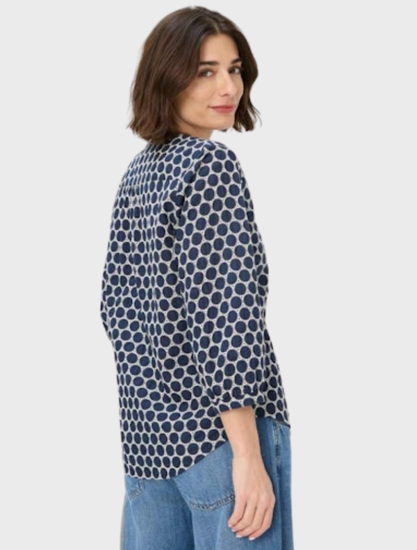 Elegant navy blouse with white polka dots, perfect for casual or formal wear.