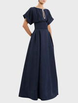 Navy sapphire gown hanging on a rack, featuring a sleek silhouette and delicate embellishments.