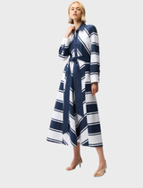 A woman in a casual navy and white striped dress, enjoying a sunny day.