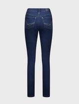 Indigo jeans stand confidently, showcasing a casual yet stylish outfit.