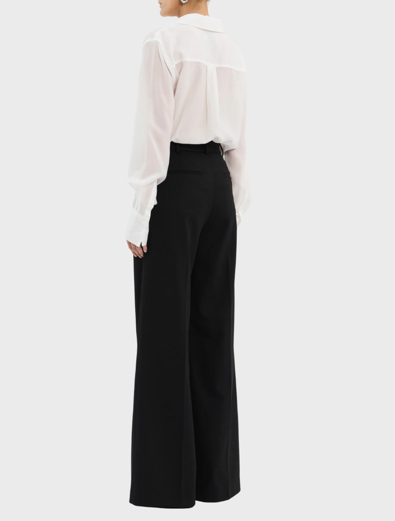The open white shirt has long sleeves, presenting a classic and airy look.