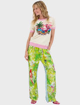 A computer screen displays a woman in a floral shirt, smiling and engaging with the camera.