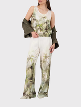 Olive tropical print top featuring a satin finish, round neckline, tank sleeves, and an elastic hem for a stylish summer look.