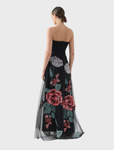 Olympia skirt featuring a black rose pattern, displayed on a hanger against a simple backdrop.