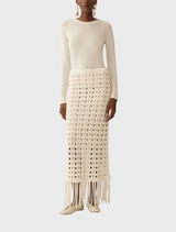 Chic off-white knit skirt with fringe accents, designed for comfort and style in both casual and dressy settings.
