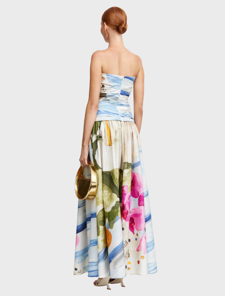 A model displays a chic floral print dress, highlighted by an array of bright flowers on a soft fabric.