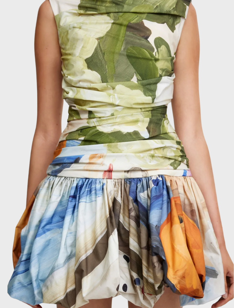 A model wears a skirt featuring a lively floral print, adding a touch of nature-inspired elegance to her outfit.