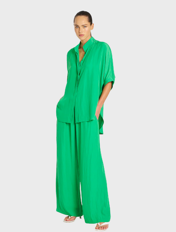 Luxurious green silk pajama set laid out, highlighting its soft fabric and stylish appearance.
