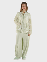Oversized lime print nylon jacket displayed on a hanger against a neutral background.