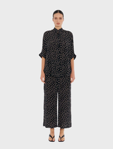 Model in a black polka dot shirt and wide-leg Pace Pant in Meringue/Black, showcasing a stylish outfit.