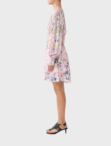 The model displays a floral print dress with a button front and frill details, designed by Palapast for a chic look.