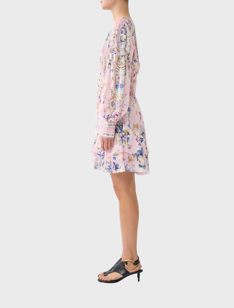 The model displays a floral print dress with a button front and frill details, designed by Palapast for a chic look.