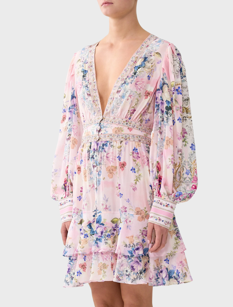 A model is dressed in a floral print Button Front Frill Dress from Palapast, highlighting its elegant and playful style.