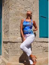 A blue tank top adorned with a colorful tropical pattern of foliage and blossoms.