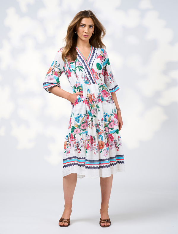 Model in a white floral dress with a v-neck, showcasing the Pandora Dress - White Multi design.