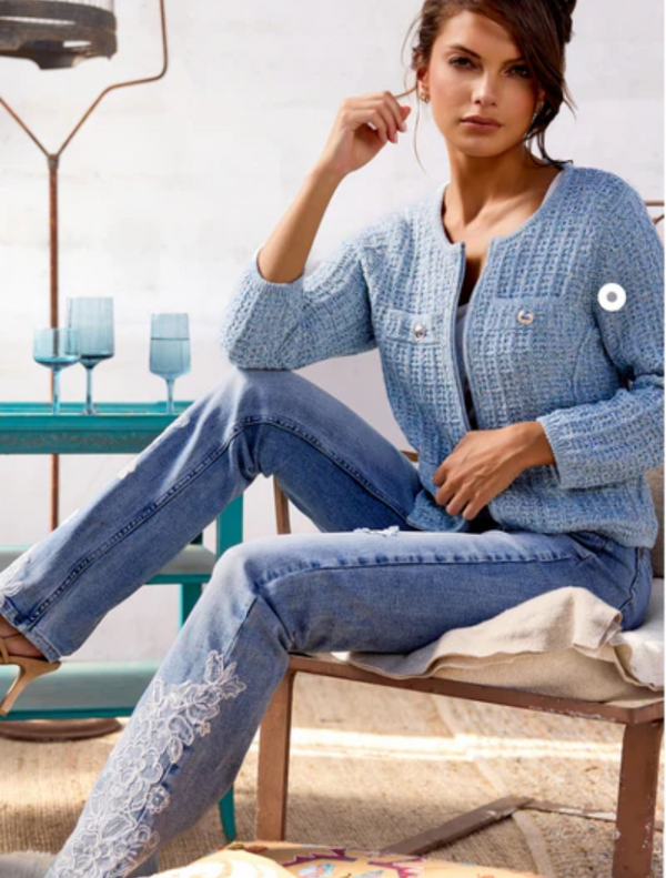 A woman in jeans with lace trim, exemplifying a fashionable style, posed against a subtle and unobtrusive background.