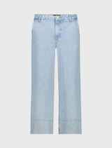 ⅞ length wide-leg jeans in light denim, featuring side pockets and a wide hem, modeled by a tall individual.
