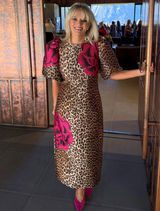 Chic leopard floral dress showcasing structured puff sleeves, a fitted shape, and a back hem split for ease of wear.