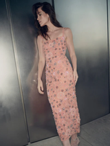 Elegant peach gown by Francesca, adorned with floral designs, showcased on a dress form in a well-lit setting.