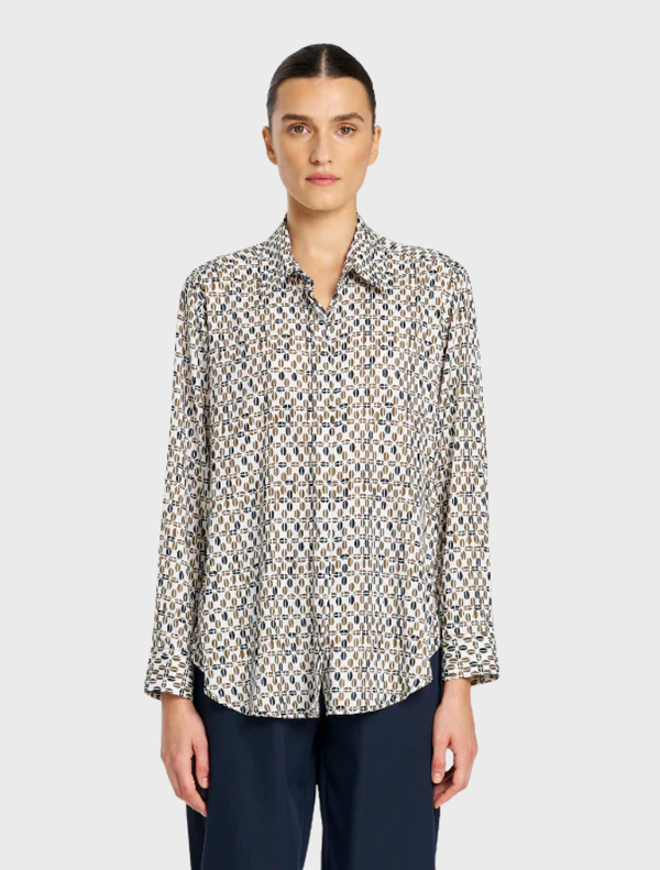 A close-up of a soft shirt adorned with a stylish pendant, highlighting its chic and comfortable appeal.