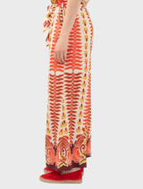 Orange Persol pants hanging on a rack, illustrating their casual style and bright hue.