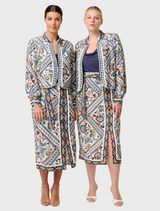 Two women in floral jackets and skirts, showcasing the Aurora Reversible Viscose & Tencel Fringe Jacket in blue ash.