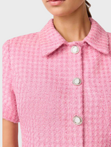 The image features a model in a pink shirt dress with prominent buttons.