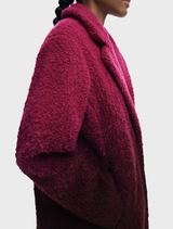 Ice cream pink coat draped elegantly, emphasizing its chic style and soft material.