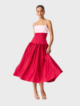 A June gown with a white top and a colorful red and pink skirt, perfect for formal occasions.