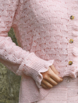 Light pink cardigan with charming ruffles along the edges, offering a trendy and cozy addition to your wardrobe.