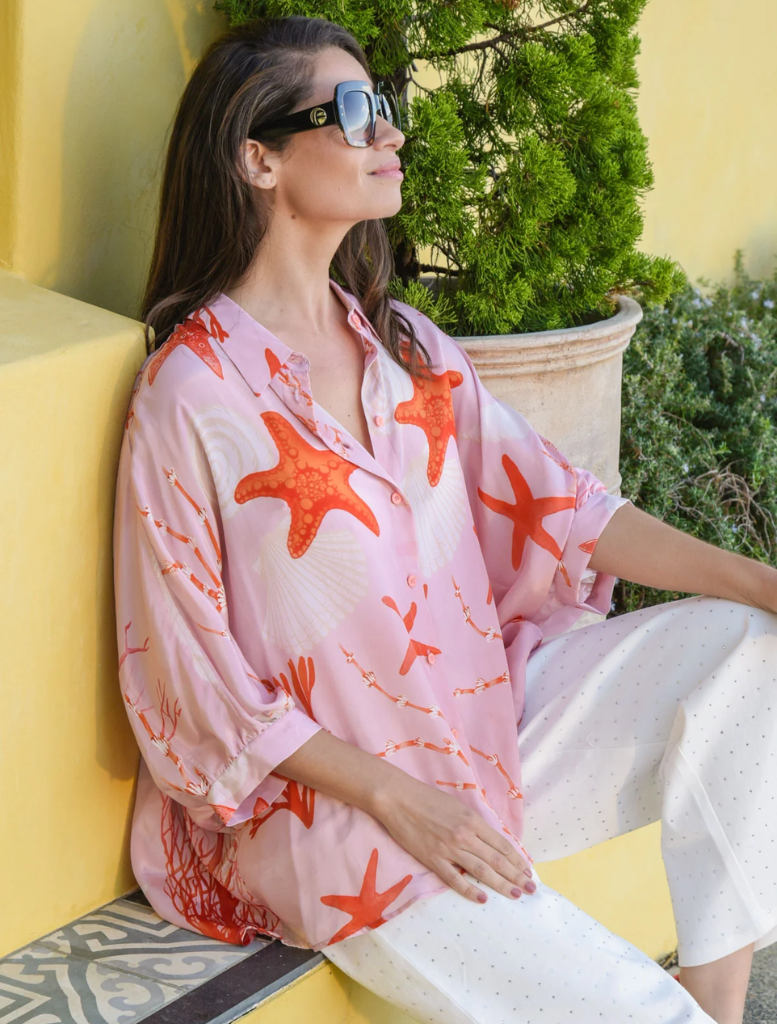 Stylish pink shell shirt showcasing a distinctive open back design, ideal for casual or semi-formal occasions.