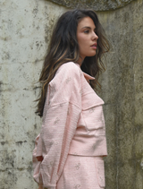 A pink Tweedle Bow Jacket with a decorative bow, designed for a chic and playful look in casual wear.
