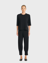 A black Plaza Crew Top laid flat, highlighting its fabric texture and crew neckline.