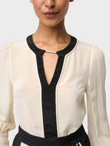 Luxurious silk blouse in a soft cloud hue, designed with pleated cuffs for an elegant touch.