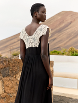 Flowing black and white dress made of viscose georgette, adorned with an ecru lace bib, offering a romantic, timeless design.