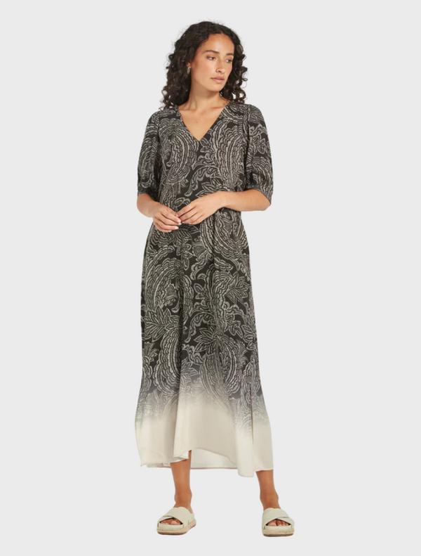 A stylish black and white dress adorned with a unique pattern, displayed on a hanger.