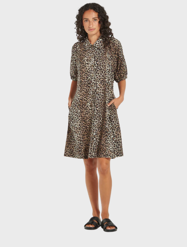 A stylish woman in a leopard print shirt and sunglasses, exuding a chic vibe while posing for the camera.