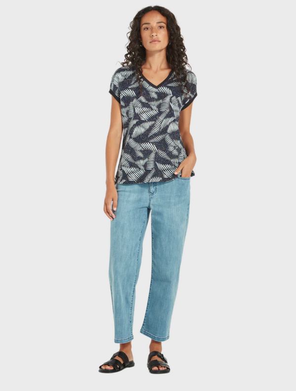 The image features a model wearing a blue top with a colorful leaf print, emphasizing a trendy and natural aesthetic.
