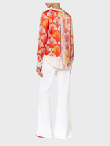 A woman sporting a vibrant tomato multi blouse and pants, reflecting a bold fashion choice.