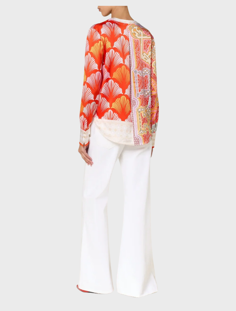A woman sporting a vibrant tomato multi blouse and pants, reflecting a bold fashion choice.