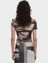 A woman in a patterned shirt, demonstrating a stylish and trendy look with a distinctive design.