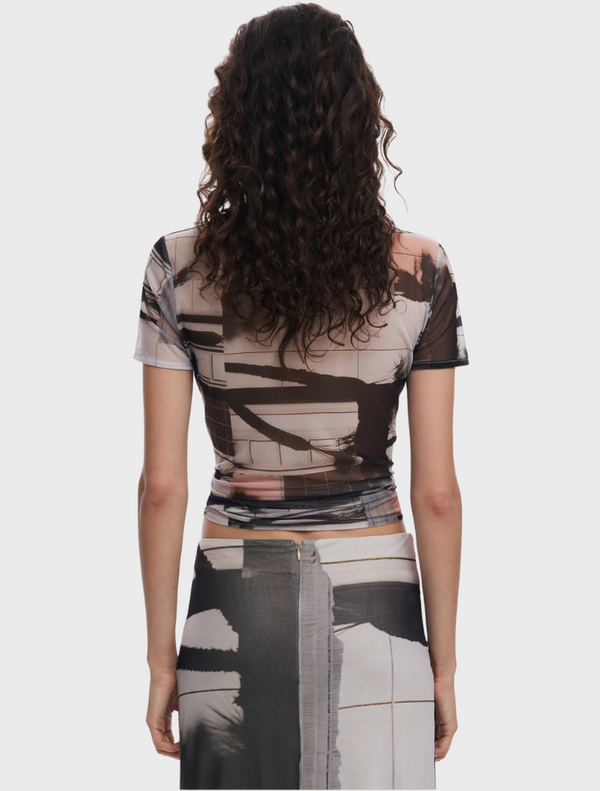 A woman in a patterned shirt, demonstrating a stylish and trendy look with a distinctive design.