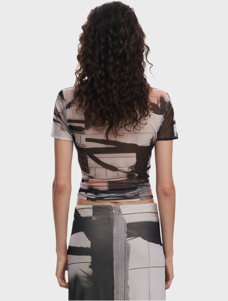 A woman in a patterned shirt, demonstrating a stylish and trendy look with a distinctive design.