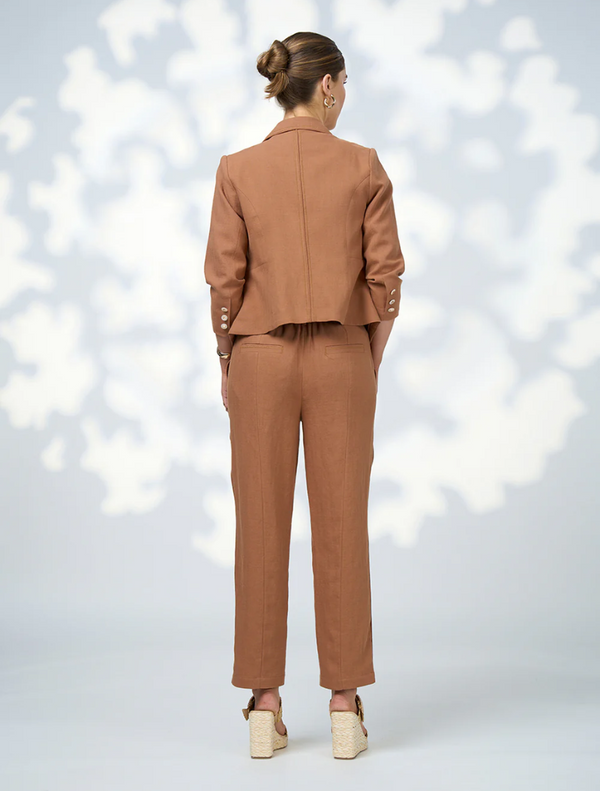 Stylish toffee Quinn pants laid flat, highlighting their tailored fit and contemporary aesthetic.