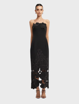 A long ebony maxi dress featuring an appliqué bustier design, showcasing elegance and style.