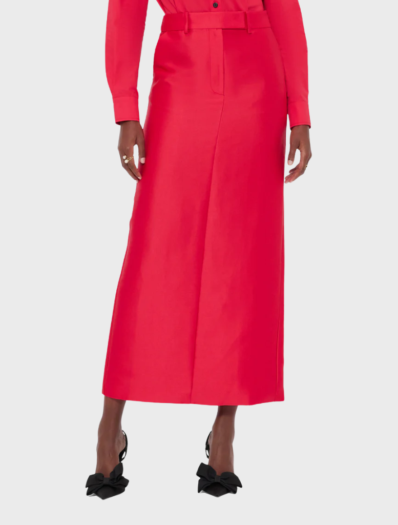 Long red pleated skirt paired with a button-down shirt, creating a stylish and elegant outfit.