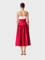 Back view of a woman in a red dress, showcasing the June Gown design in pink and red hues.